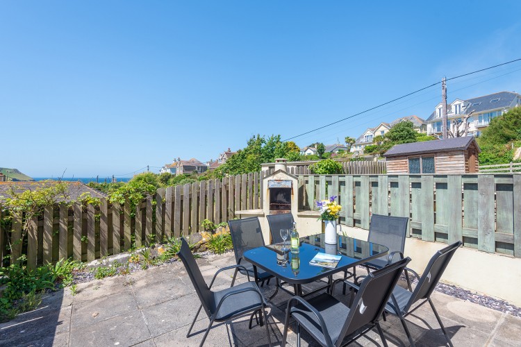 The sunny patio with a barbecue area, to house disposable barbecues, and views of the sea.
