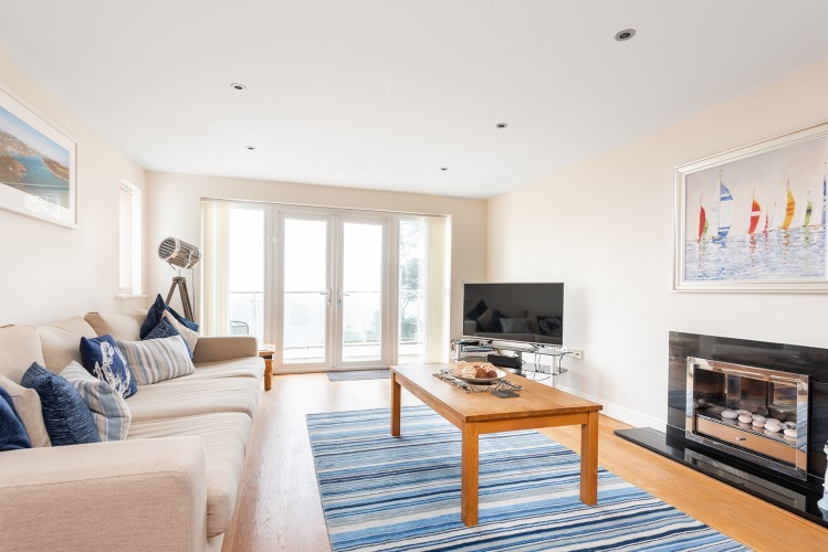 The living room with stunning views across the estuary and access to the balcony
